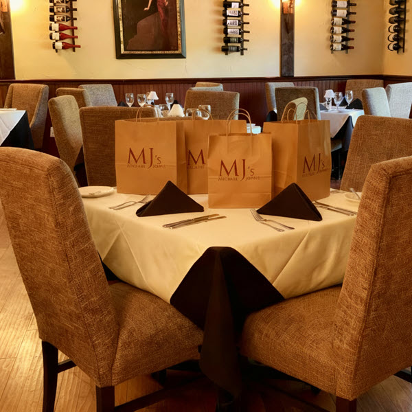 Image of MJs takeout bags on a dining room table